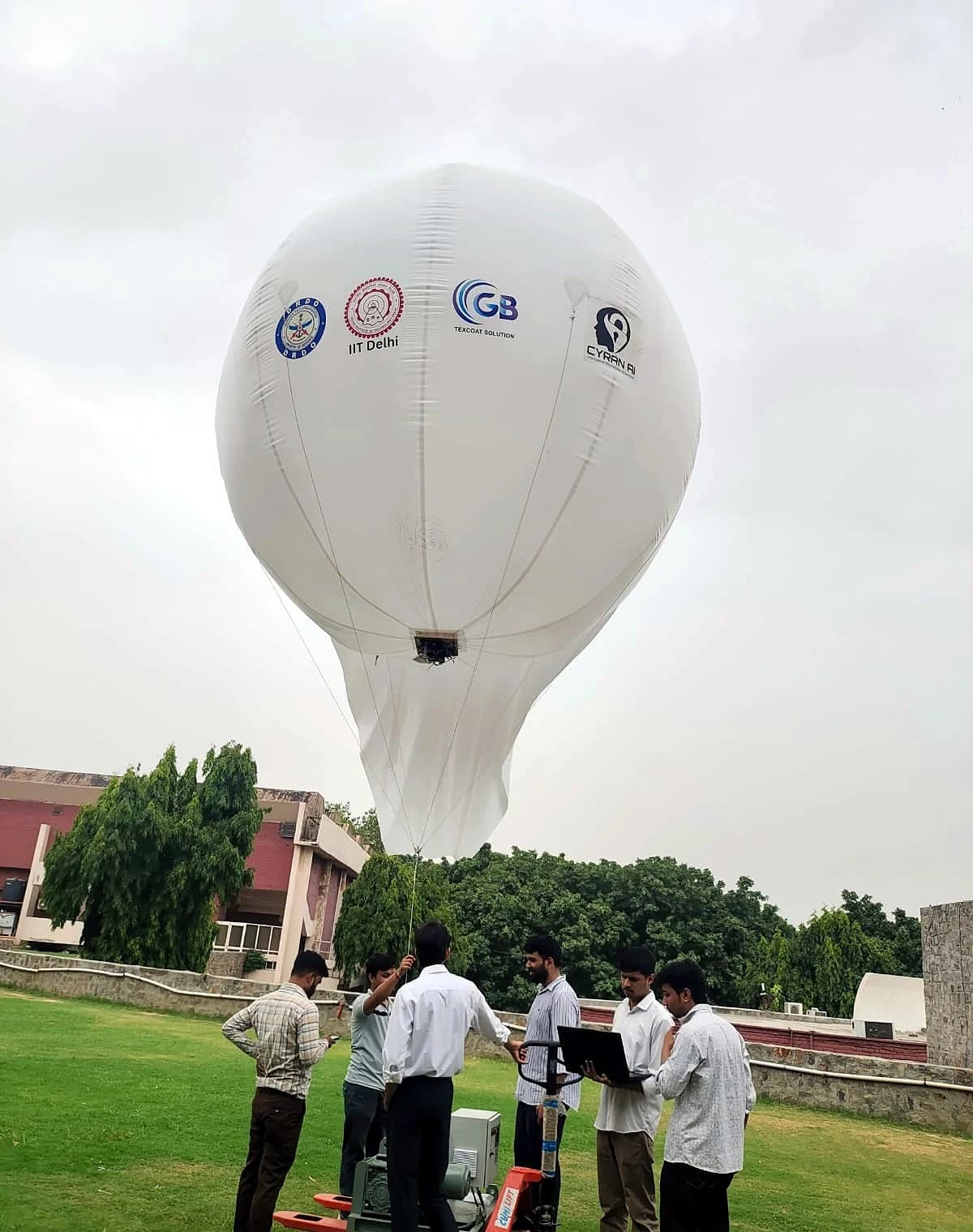 Ground crew preparing the tethered aerostat for launch, GB Texcoat and partner logos visible on the envelope